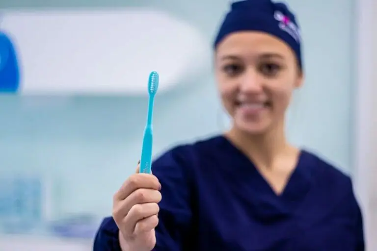 Imagem de médica dentista a segurar numa escova de dentes